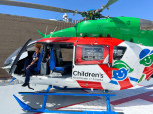 A nursing student is on top of a helicopter for a children's pediatric unit.